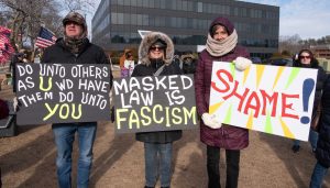 Local activists hold signs at protest